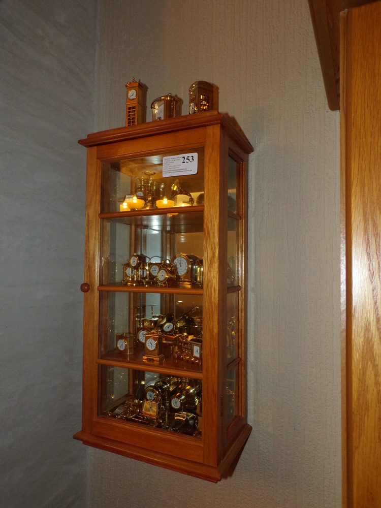 Collection of brass miniature timepieces with cabinet